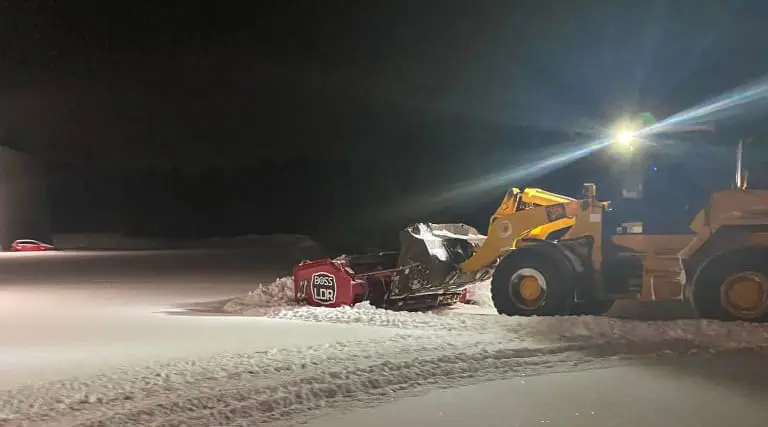 A loader providing Commercial Snow Management in a business parking lot