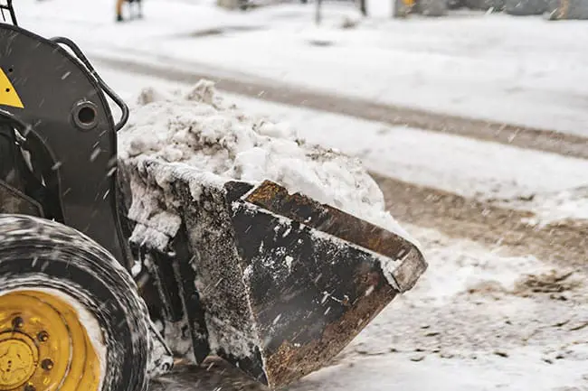 A bucket loader doing snow removal at a business in Portland Maine